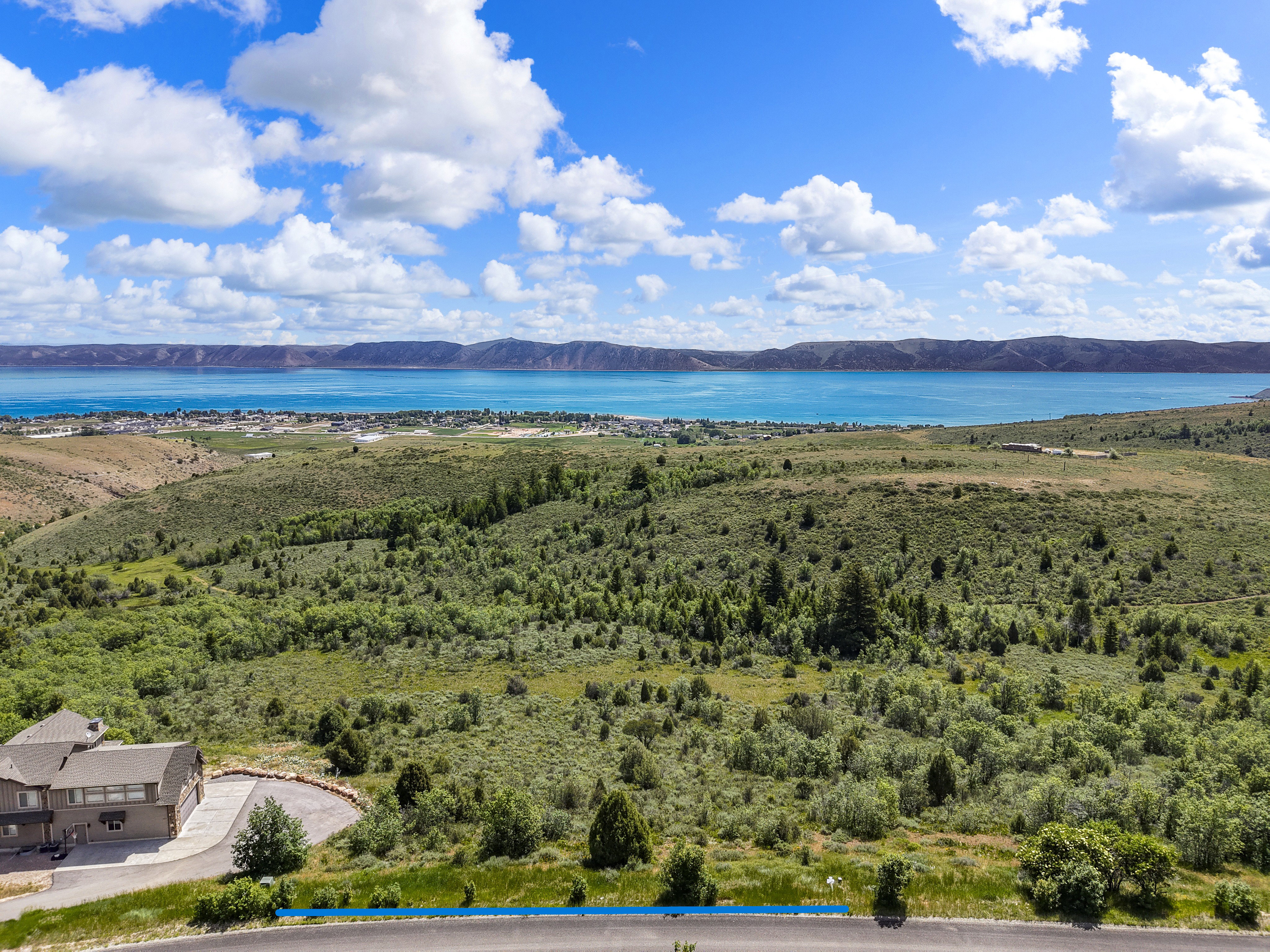 Expansive land parcel with natural landscaping, offering broad water and distant mountain scenery