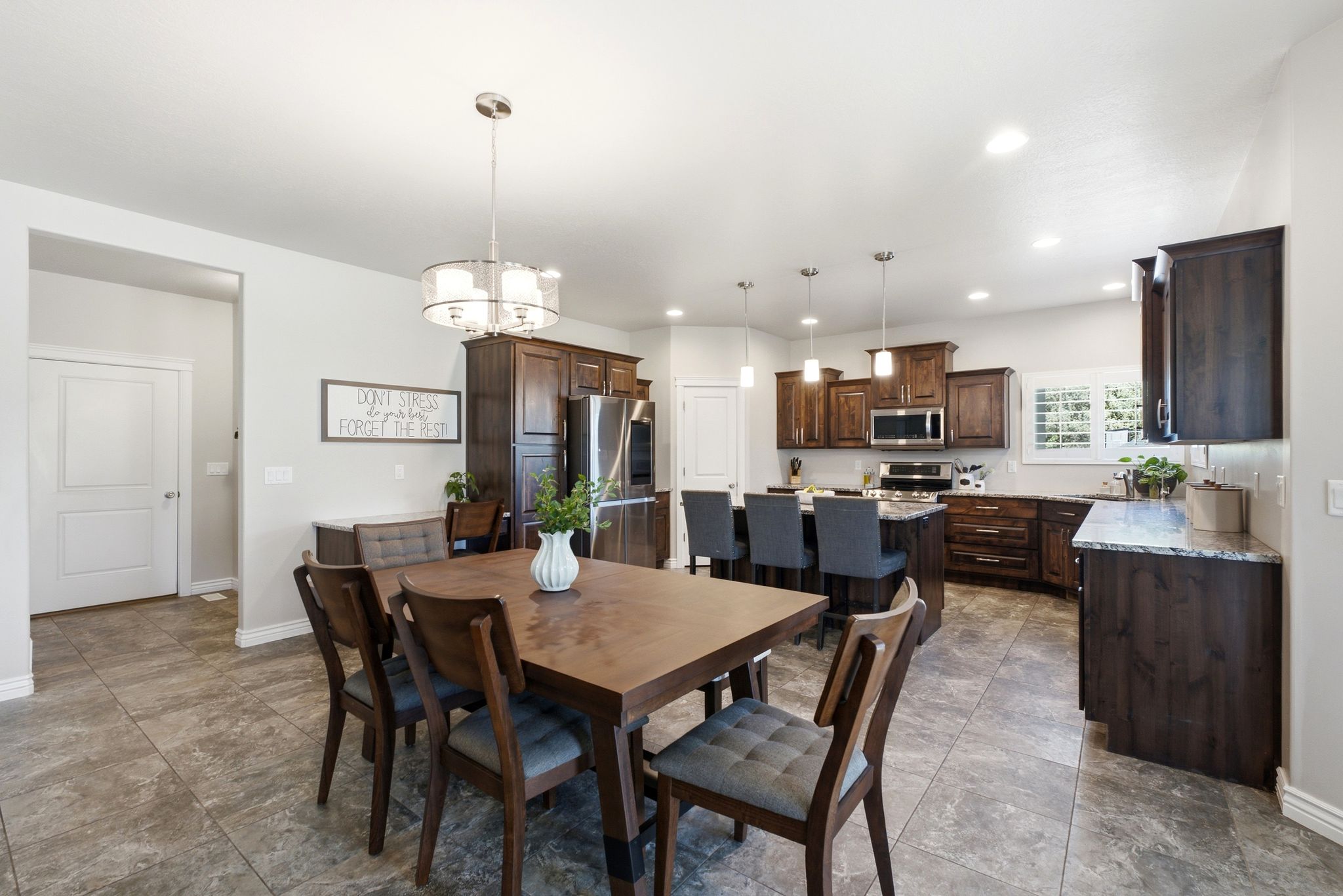 Open-concept kitchen and dining area featuring stone-look tile flooring