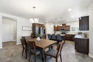 Open-concept kitchen and dining area featuring stone-look tile flooring