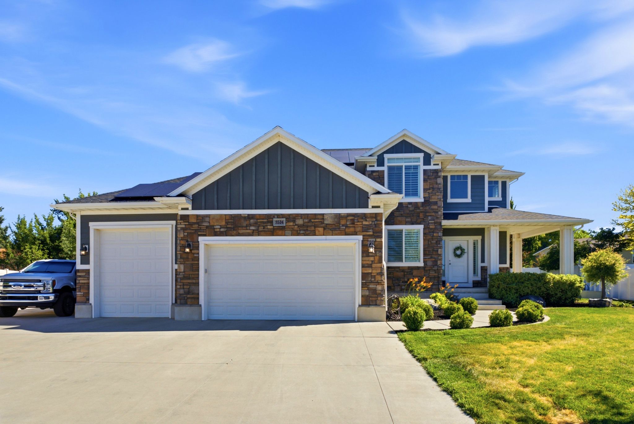 Multi-story residence featuring a combination of stone and siding exterior