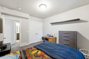 Bedroom featuring light gray walls, carpet flooring, a flush-mount ceiling light, and white bi-fold closet doors