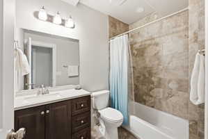 Bathroom featuring a vanity with dark wood-finish cabinetry, a white countertop with an integrated sink, and a chrome faucet