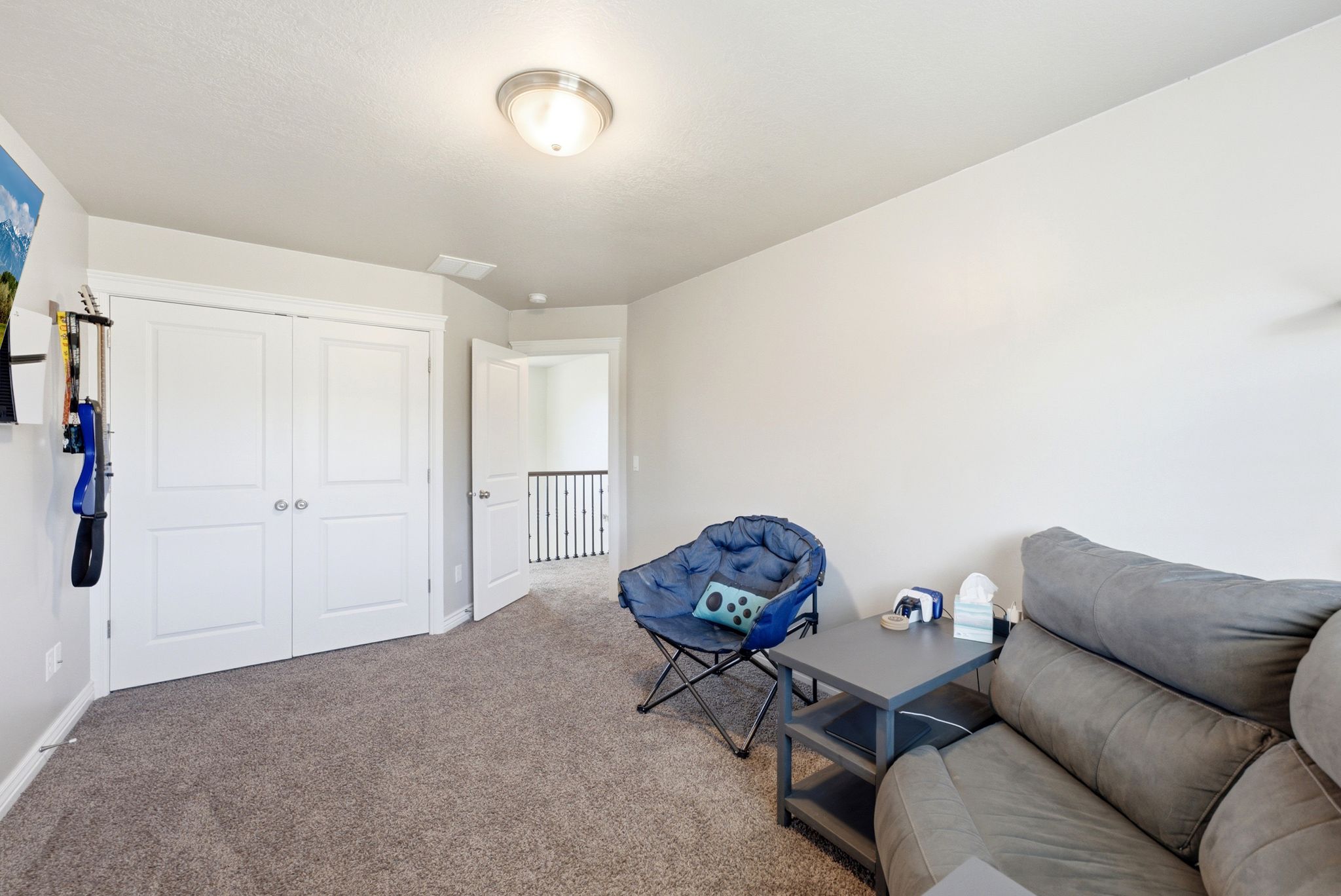 Carpeted room featuring a double-door closet with white paneled doors, light grey walls, and a recessed ceiling light fixture