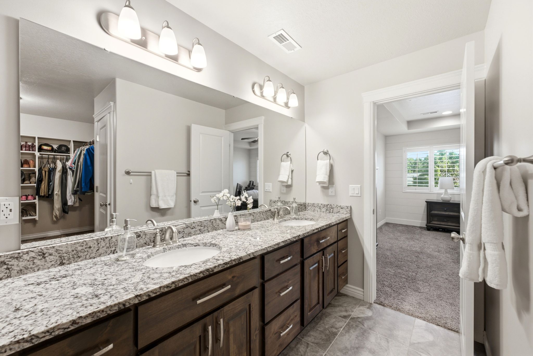 Dual vanity with granite countertop, undermount sinks, and dark wood-finish cabinetry