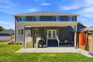 Rear exterior featuring a covered patio, stucco finish, and multiple windows with plantation shutters
