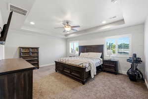 Spacious room featuring a tray ceiling with recessed lighting, a ceiling fan, and light-colored carpeting