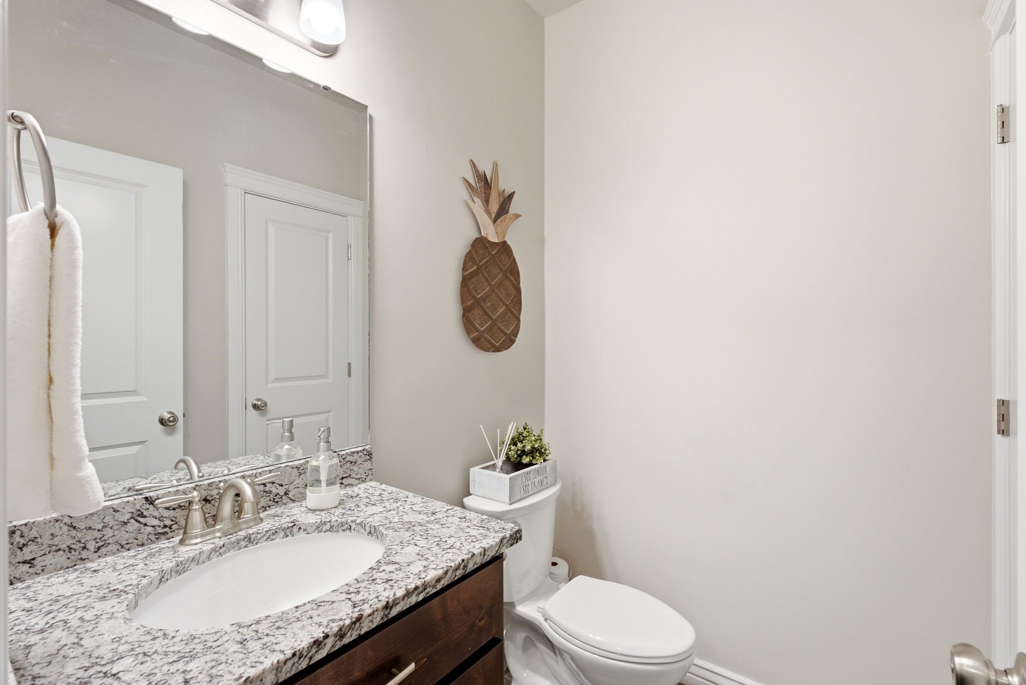 Vanity with a granite countertop, undermount sink, and brushed nickel faucet