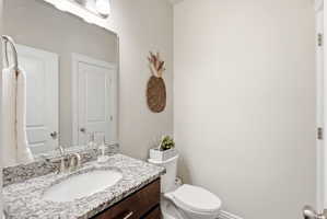 Vanity with a granite countertop, undermount sink, and brushed nickel faucet