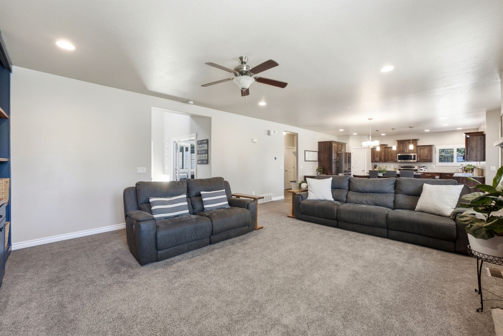 Spacious living area with recessed lighting, ceiling fan, and carpet flooring
