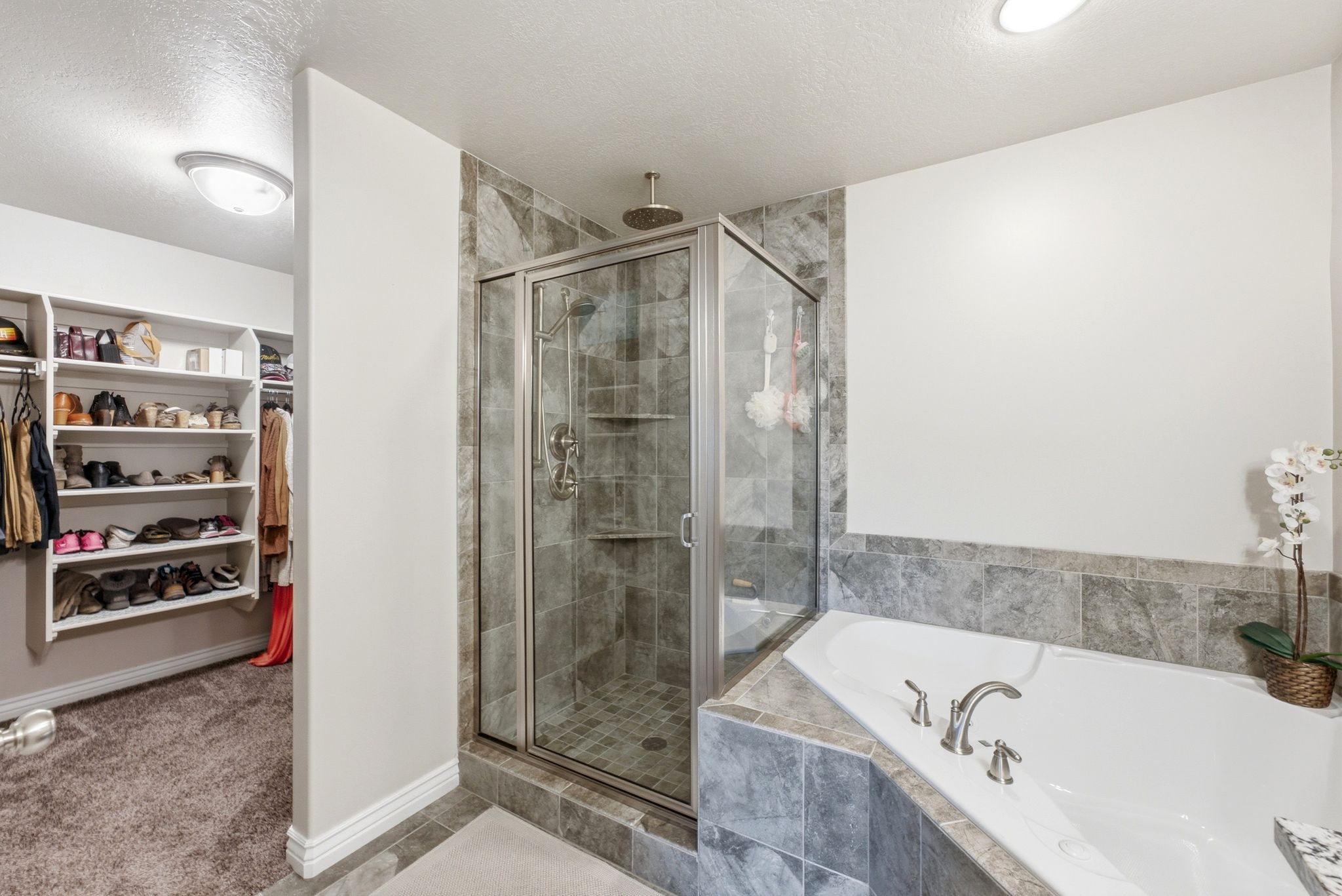 Bathroom featuring a glass-enclosed shower with tile surround, a corner soaking tub with tile surround, brushed nickel fixtures, and recessed lighting