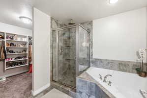 Bathroom featuring a glass-enclosed shower with tile surround, a corner soaking tub with tile surround, brushed nickel fixtures, and recessed lighting
