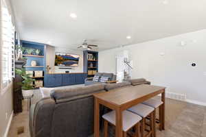 Open-concept living area featuring a custom built-in entertainment center with blue cabinetry and wood-finish countertops