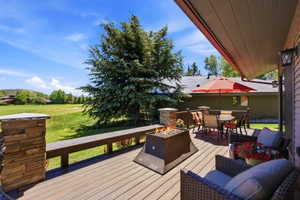 Expansive outdoor deck featuring wood-finish flooring and a built-in fire pit