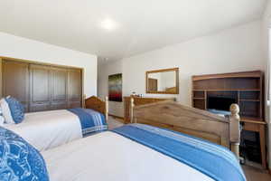 Spacious room featuring light-toned walls and wood-finish flooring