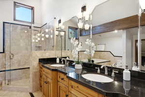 Dual wood vanities with dark countertops and undermount sinks