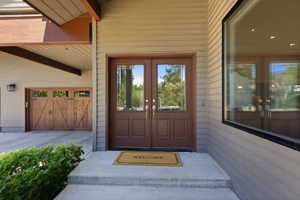 Exterior facade featuring horizontal siding, a double entry door with glass inserts, and an expansive window