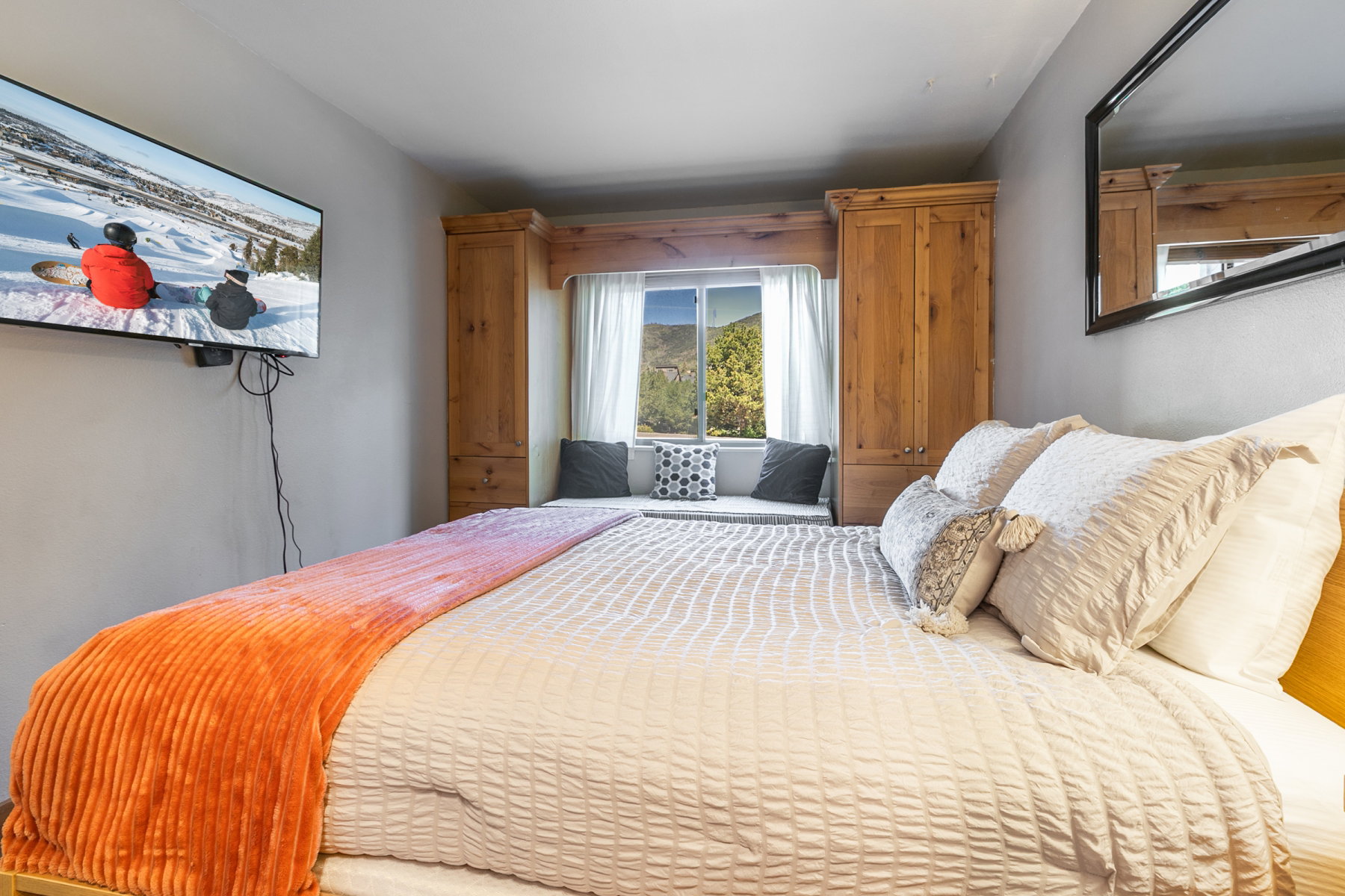 Bedroom featuring a built-in window seat, a window with outdoor scenery, and integrated wood-finish cabinetry