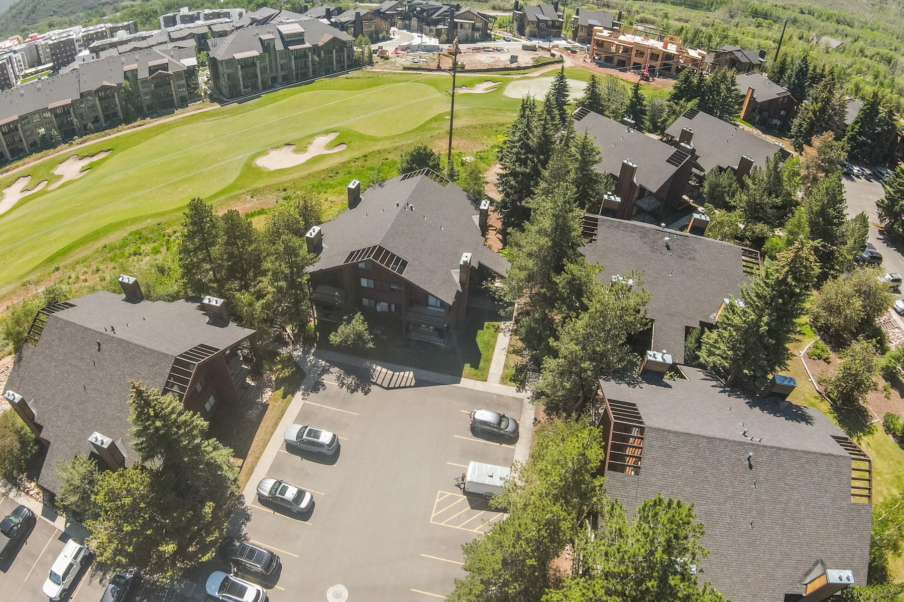 Aerial view of a residential complex featuring multiple buildings with dark-toned roofs and exterior siding