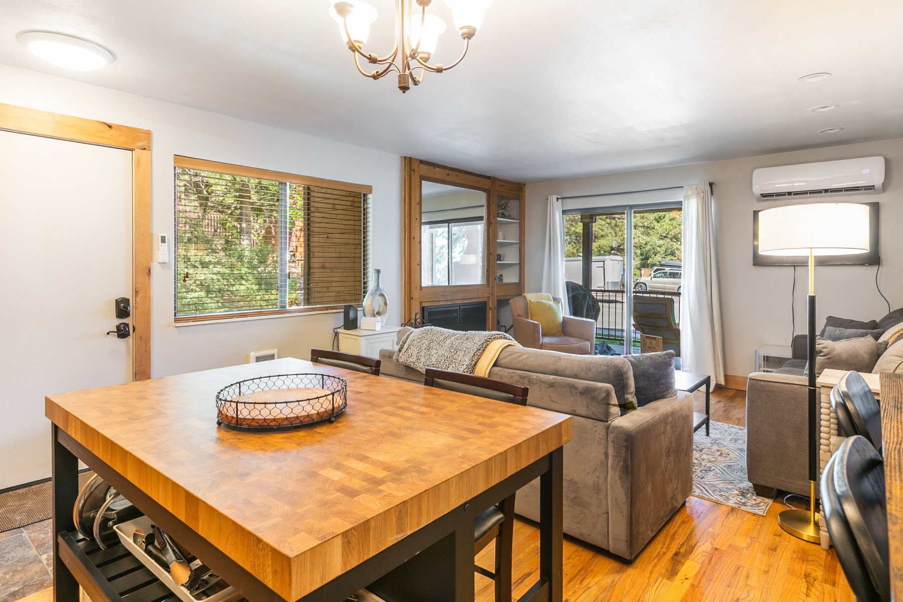 Open-concept living space with wood-finish flooring and a butcher block island