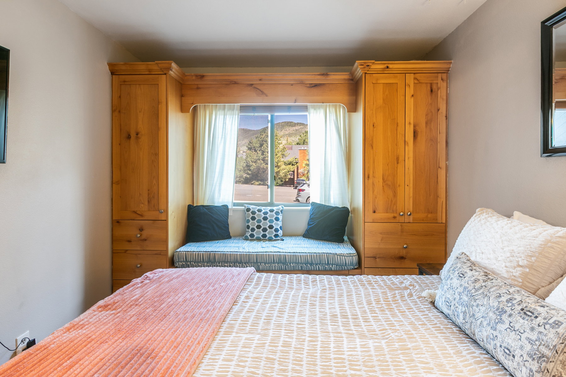 Built-in window seat with integrated wood cabinetry and drawers, creating a cohesive storage solution