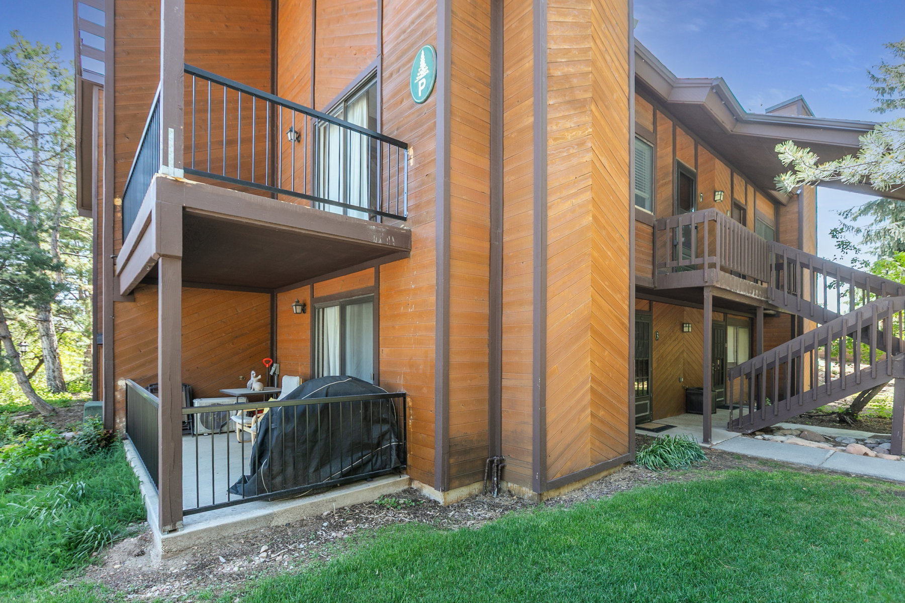Wood-sided exterior featuring multiple private patios and balconies with dark railings