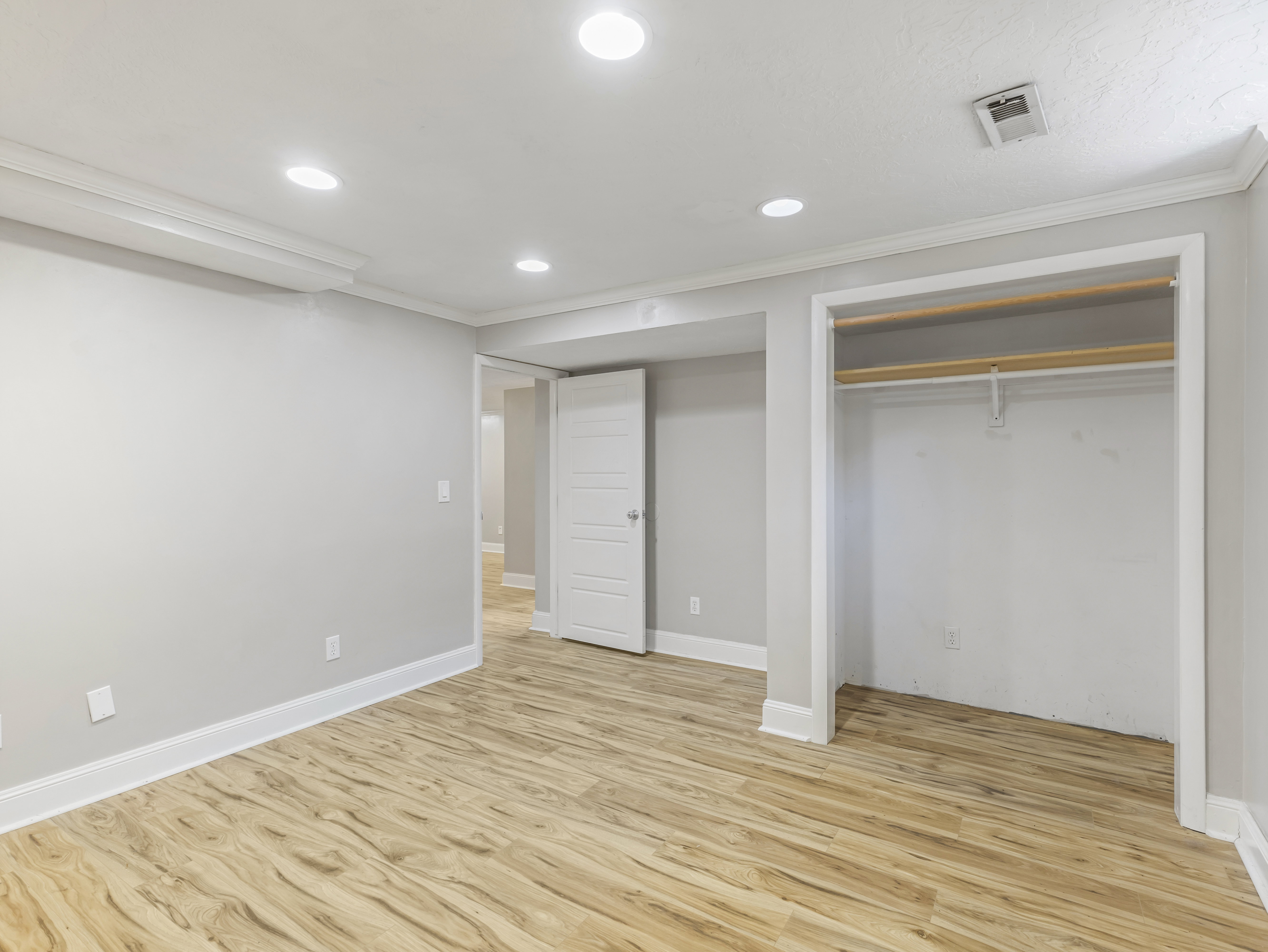 Bright room with wood-finish flooring and recessed lighting
