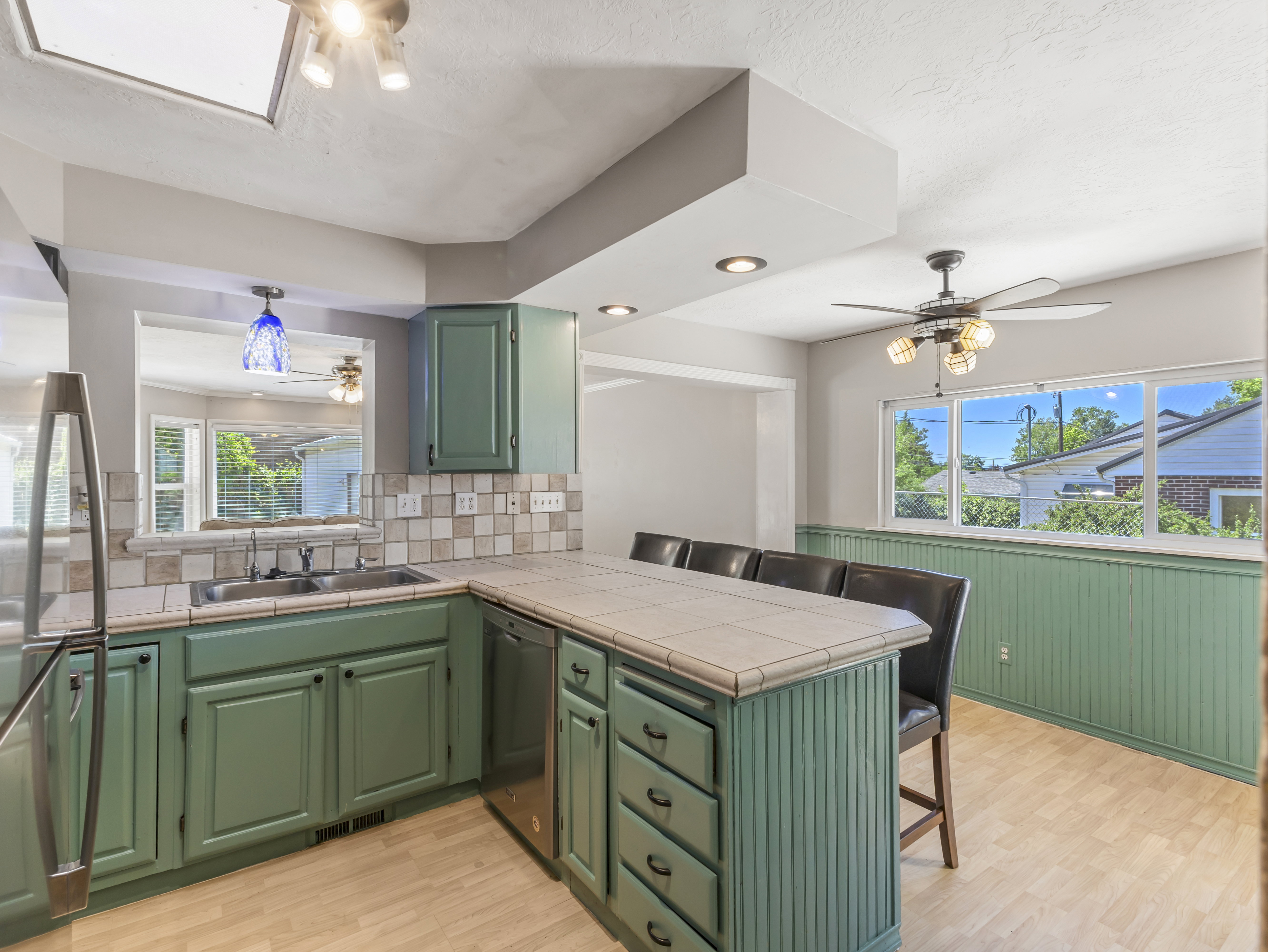 Kitchen featuring green cabinetry, tile countertops, and a tile backsplash