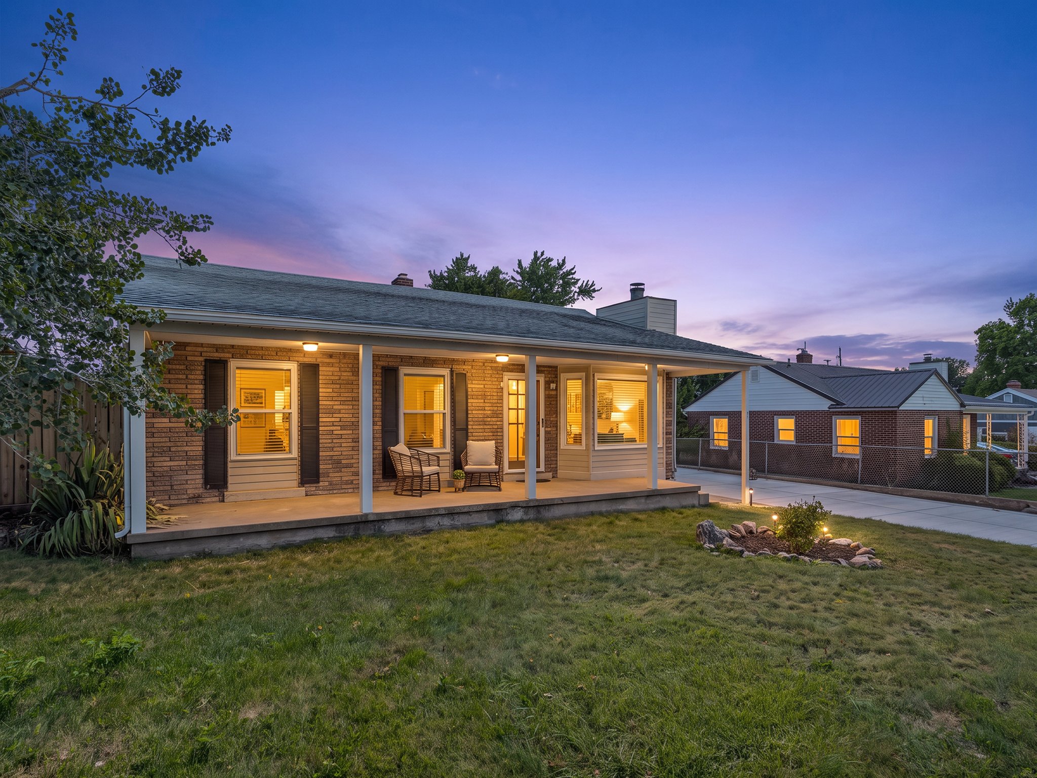 Brick exterior with dark shutters and a covered front porch featuring recessed lighting