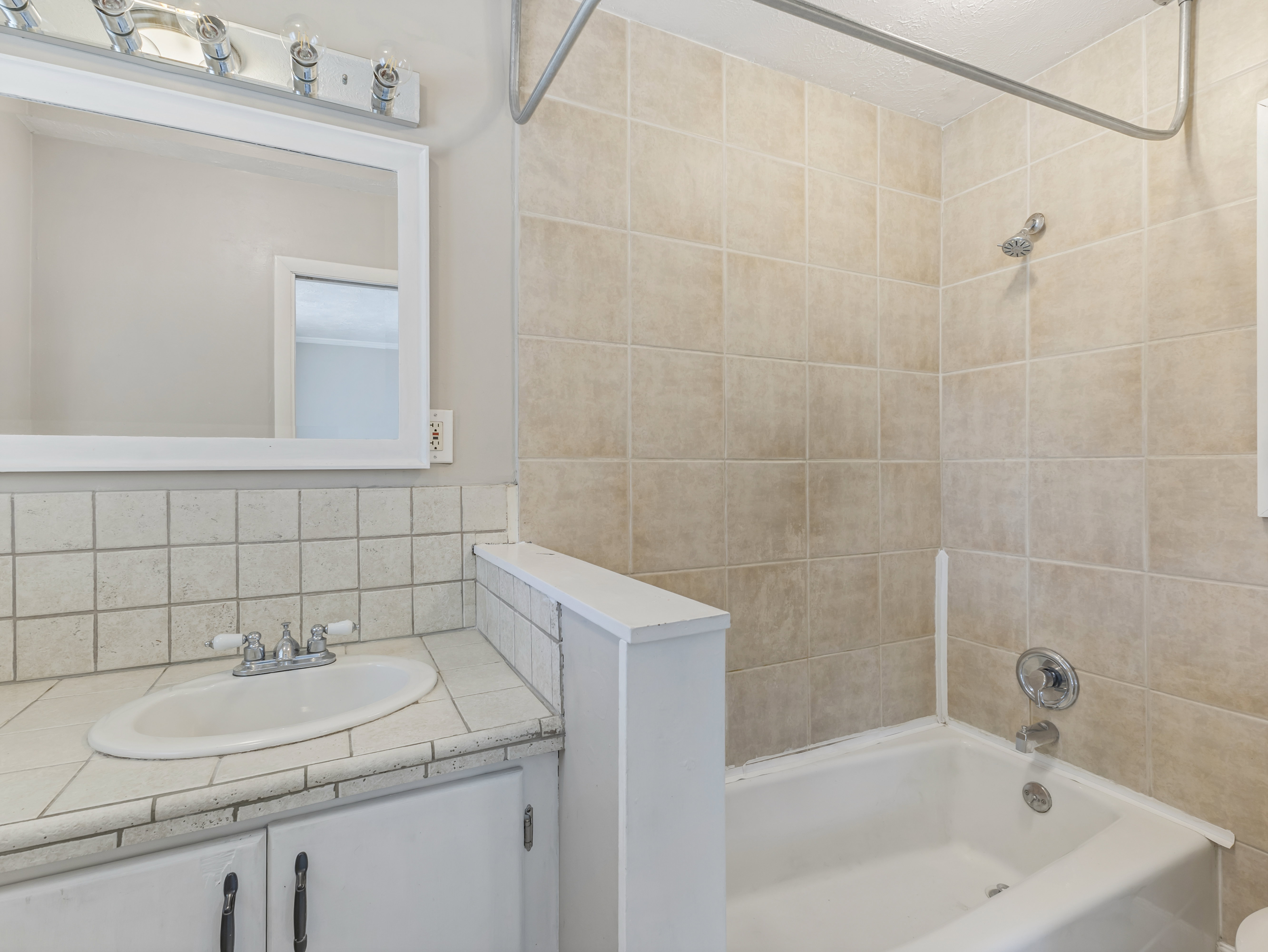Bathroom vanity with a white framed mirror and overhead vanity lighting
