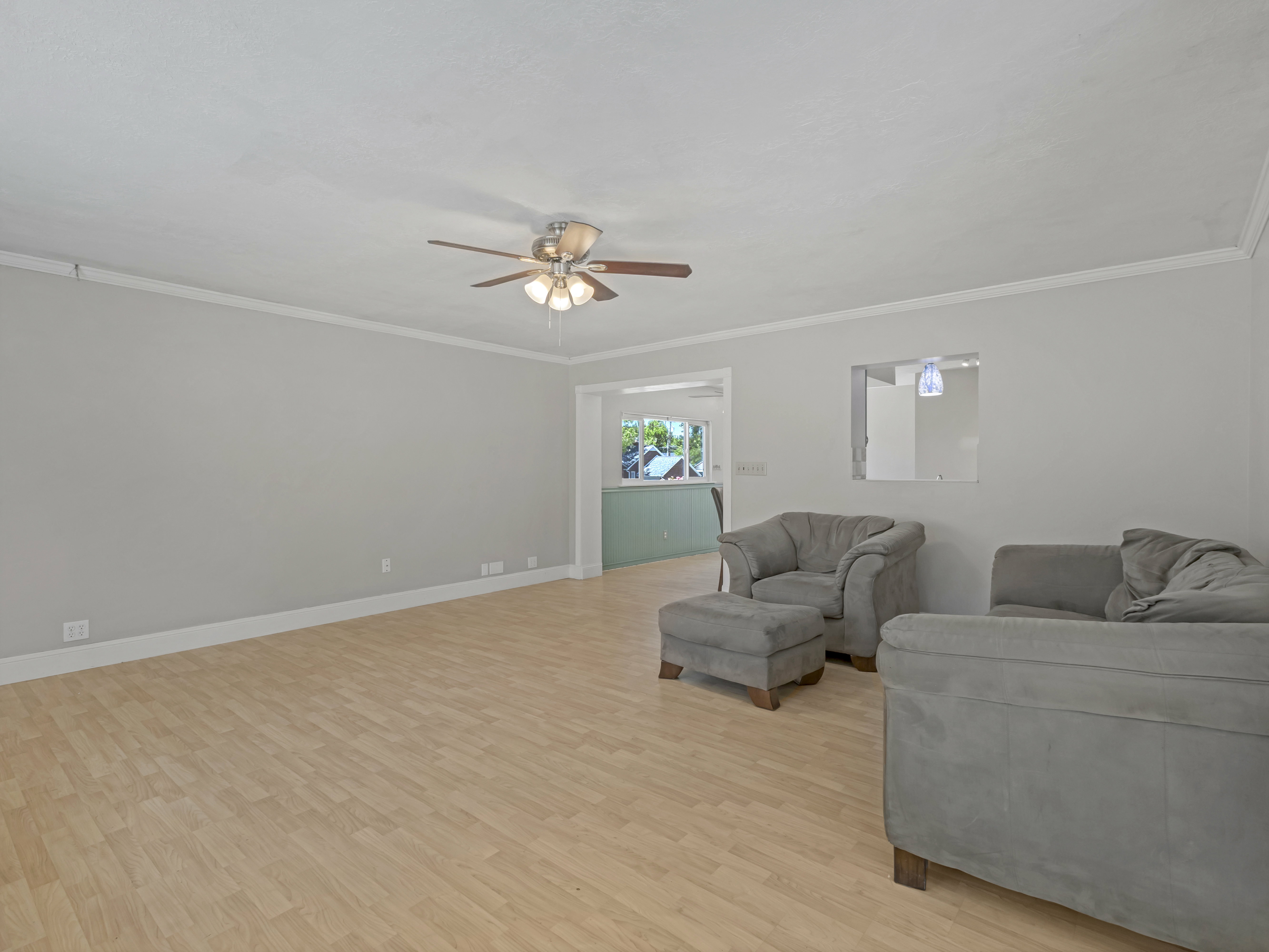 Spacious room with wood-finish flooring and crown molding