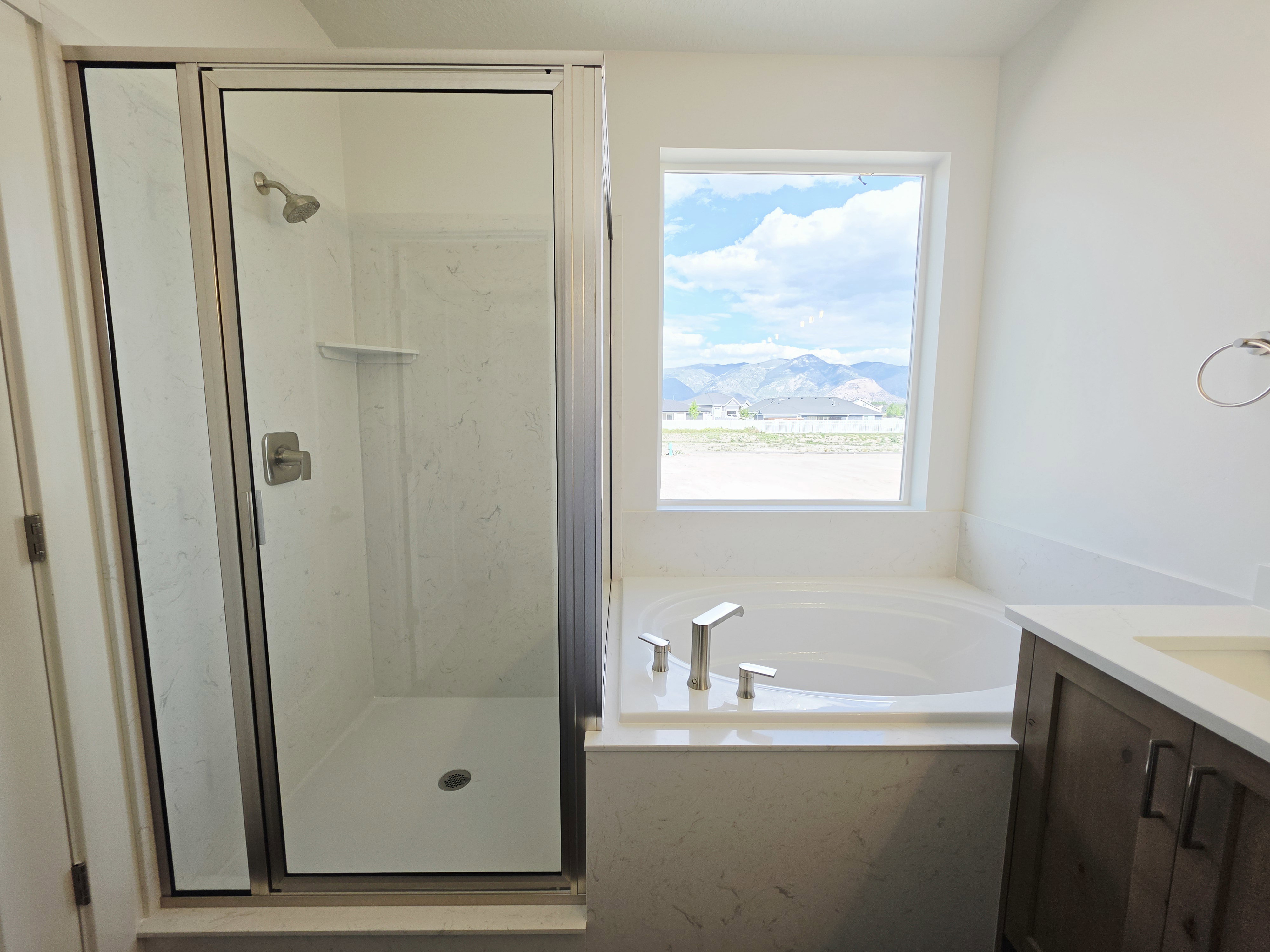 Contemporary bathroom featuring a glass-enclosed shower with a chrome shower head and a built-in tub with chrome fixtures