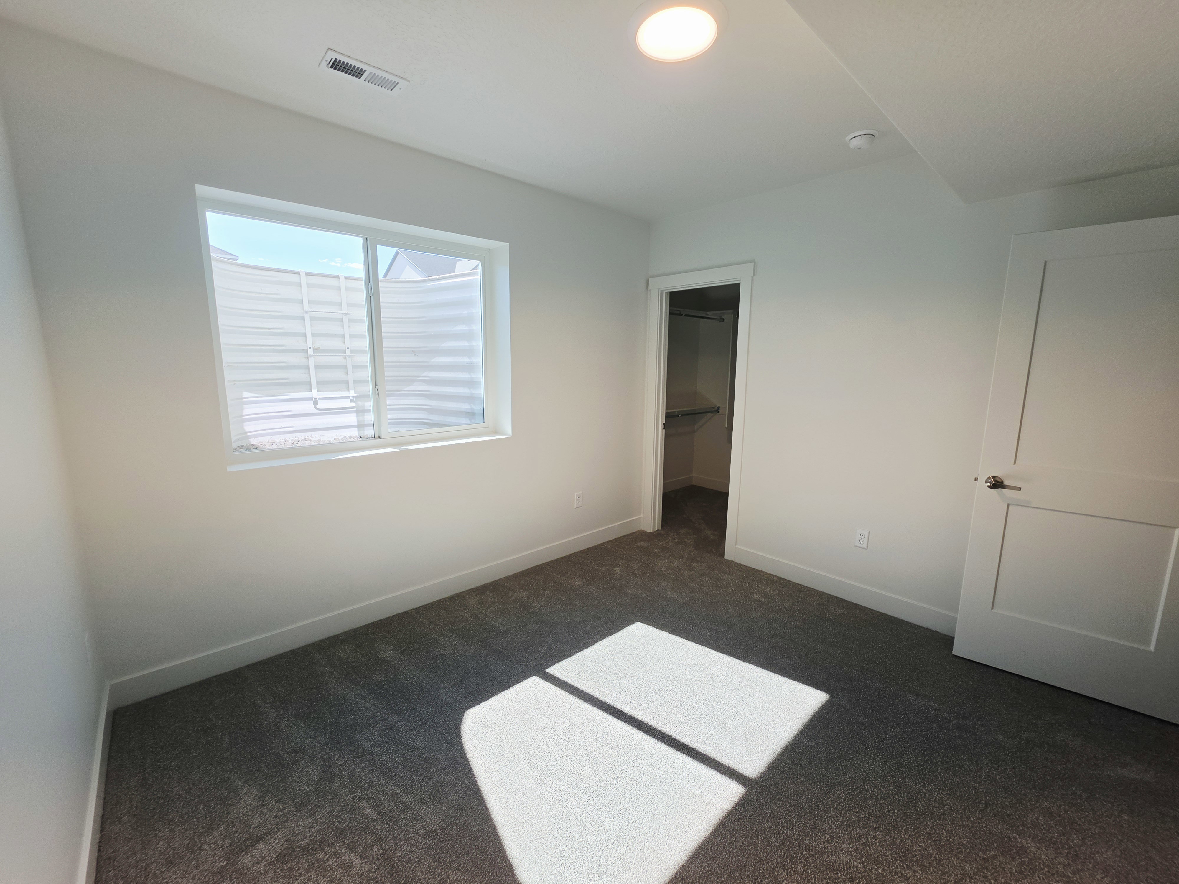White interior walls featuring a single window and recessed lighting