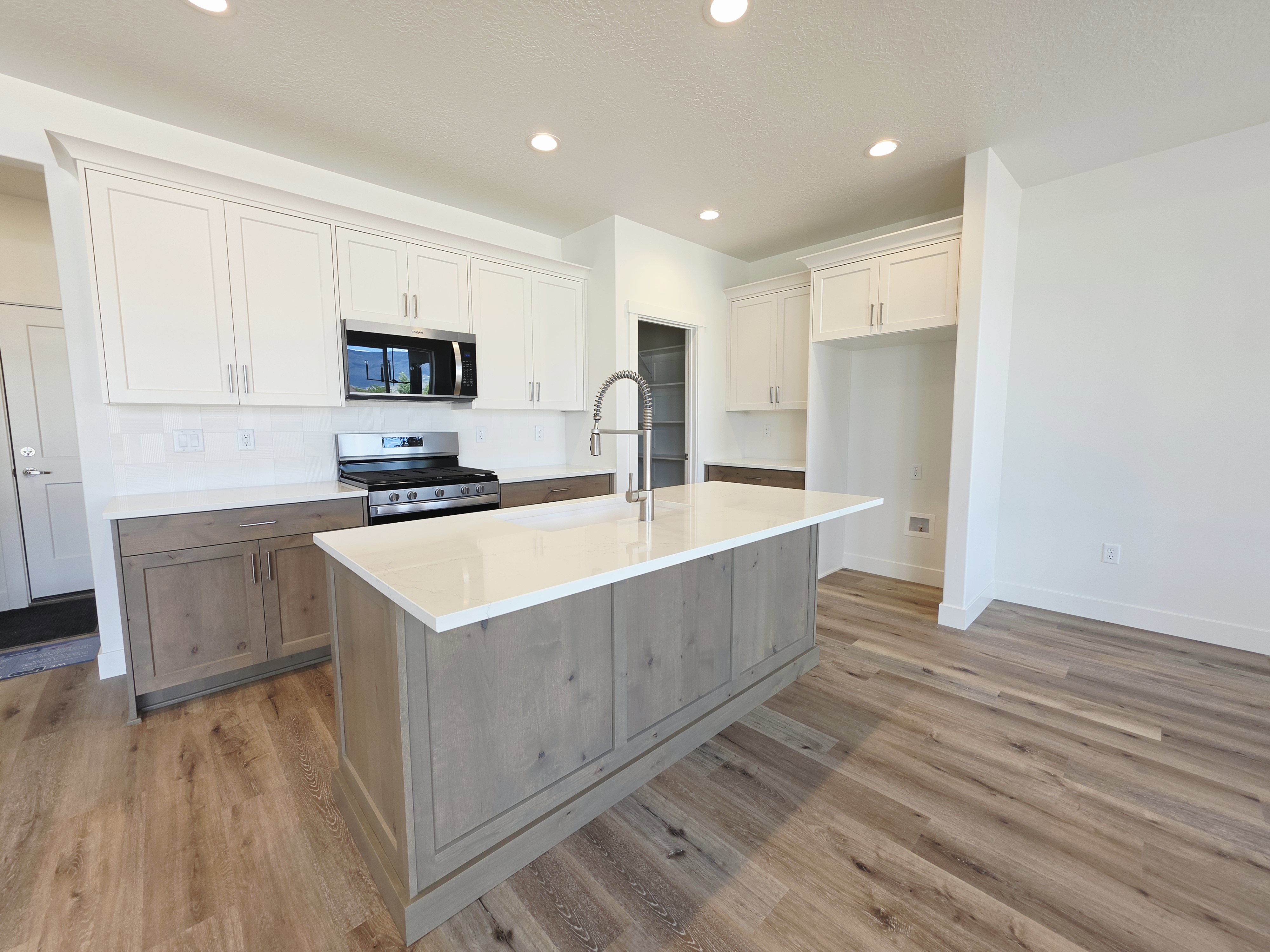 Kitchen with a central island featuring a white countertop and wood-finish paneling