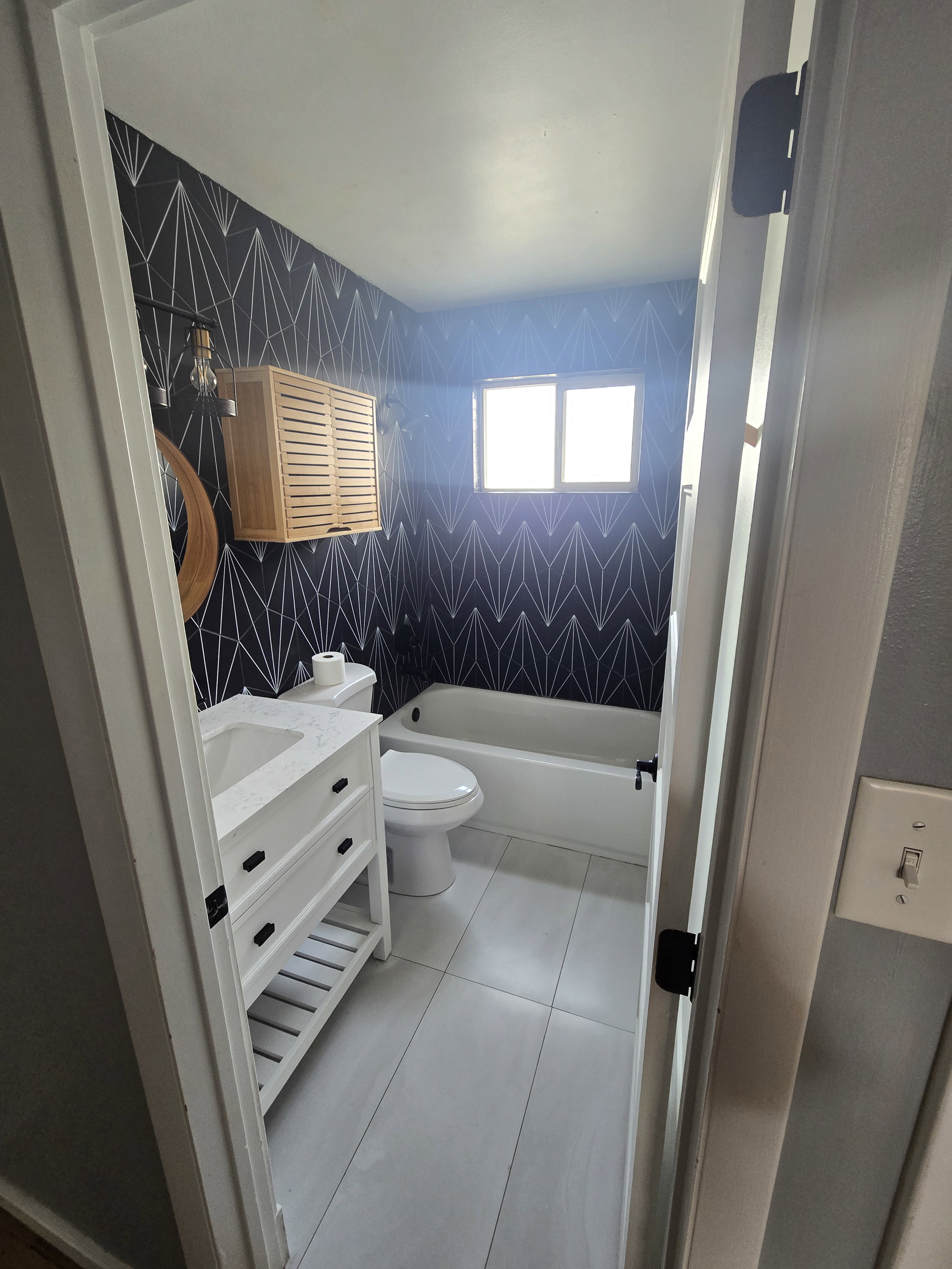 Bathroom featuring a white vanity with integrated sink, a white bathtub, and a toilet