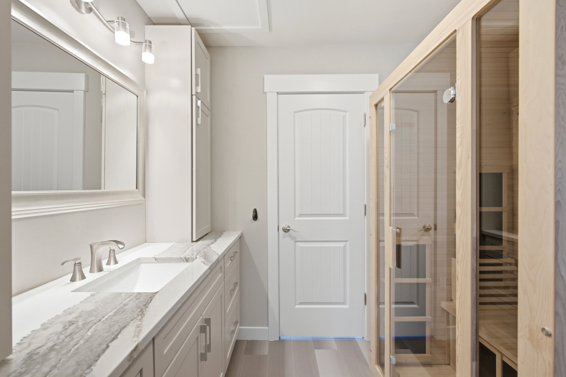 Contemporary bathroom featuring a light wood-framed glass sauna