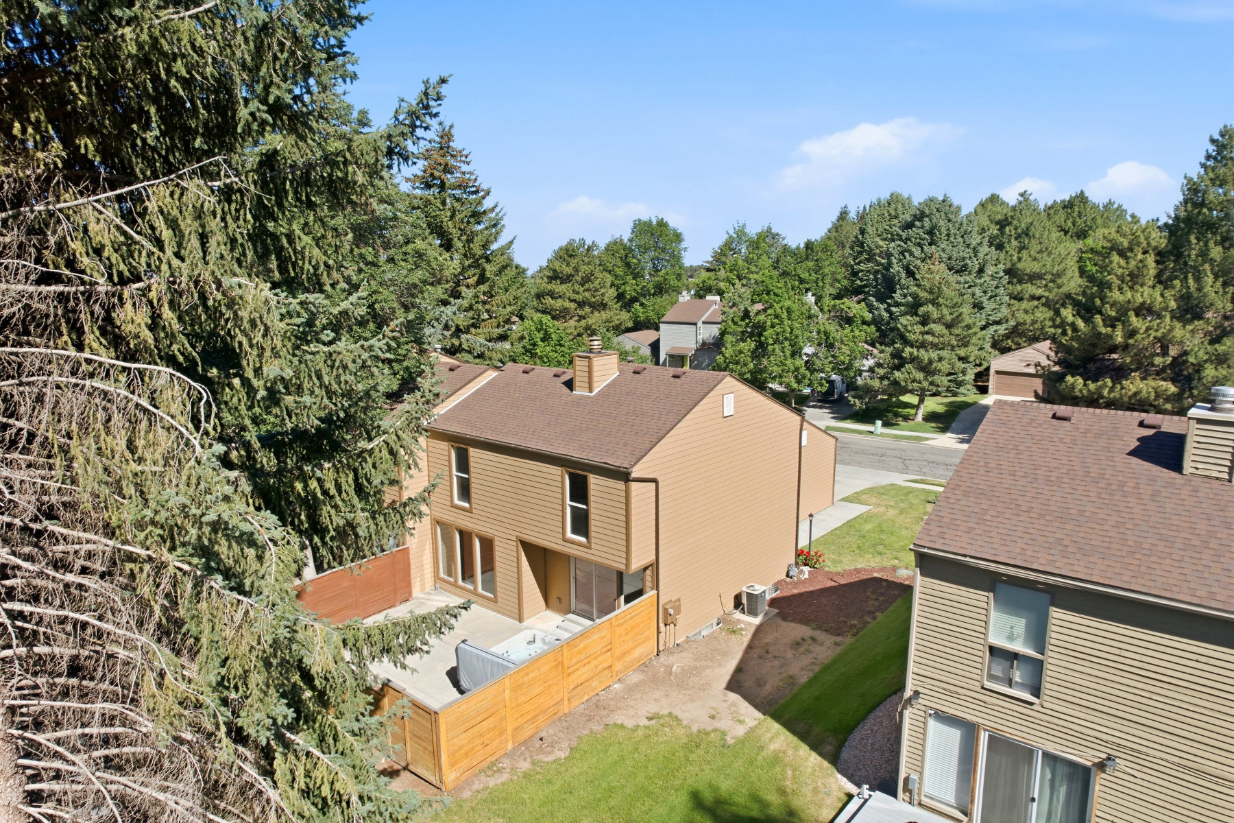 Property exterior with light brown siding and a brown shingled roof