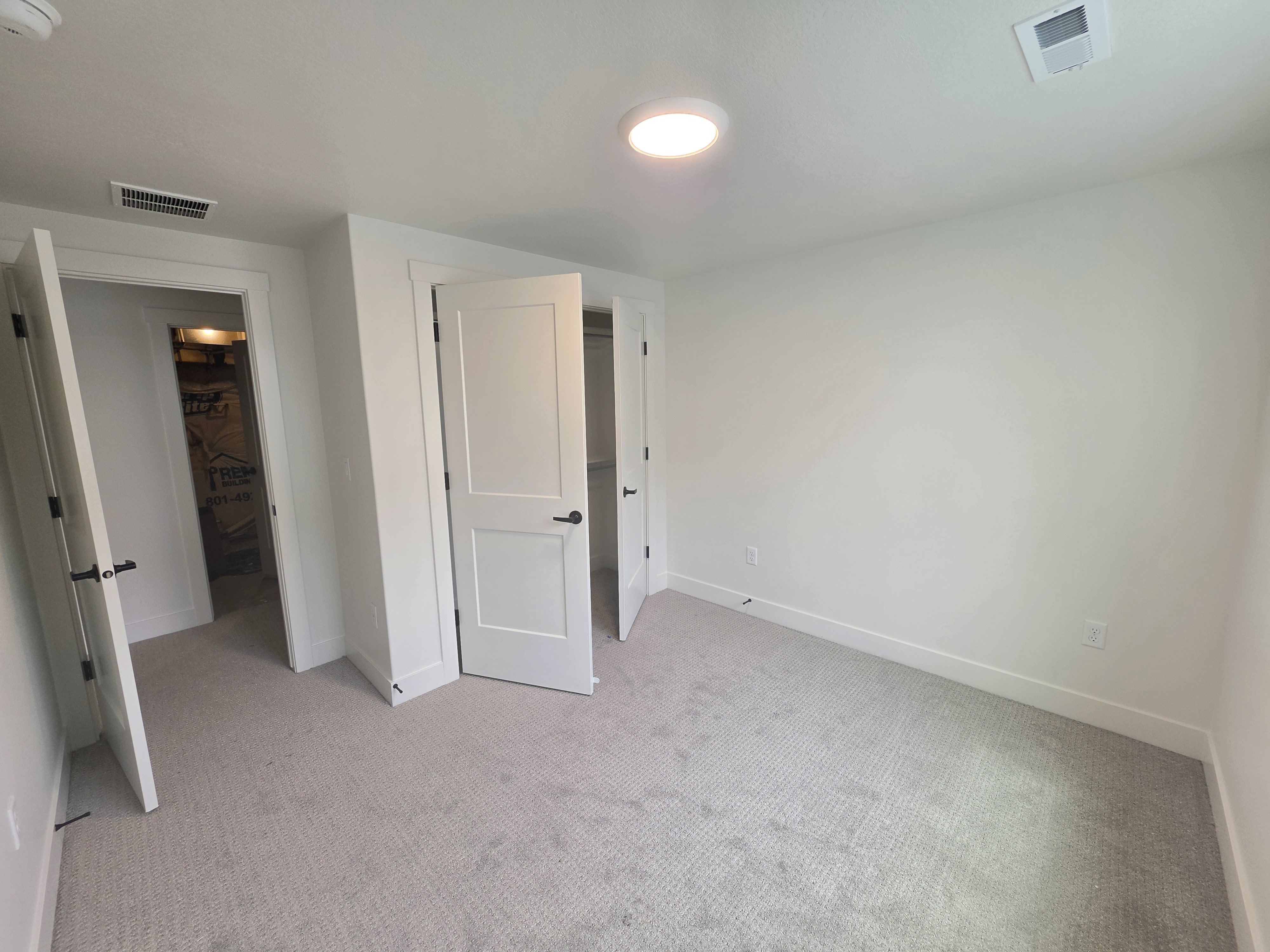 Neutral-toned wall-to-wall carpeting complements clean white walls and trim