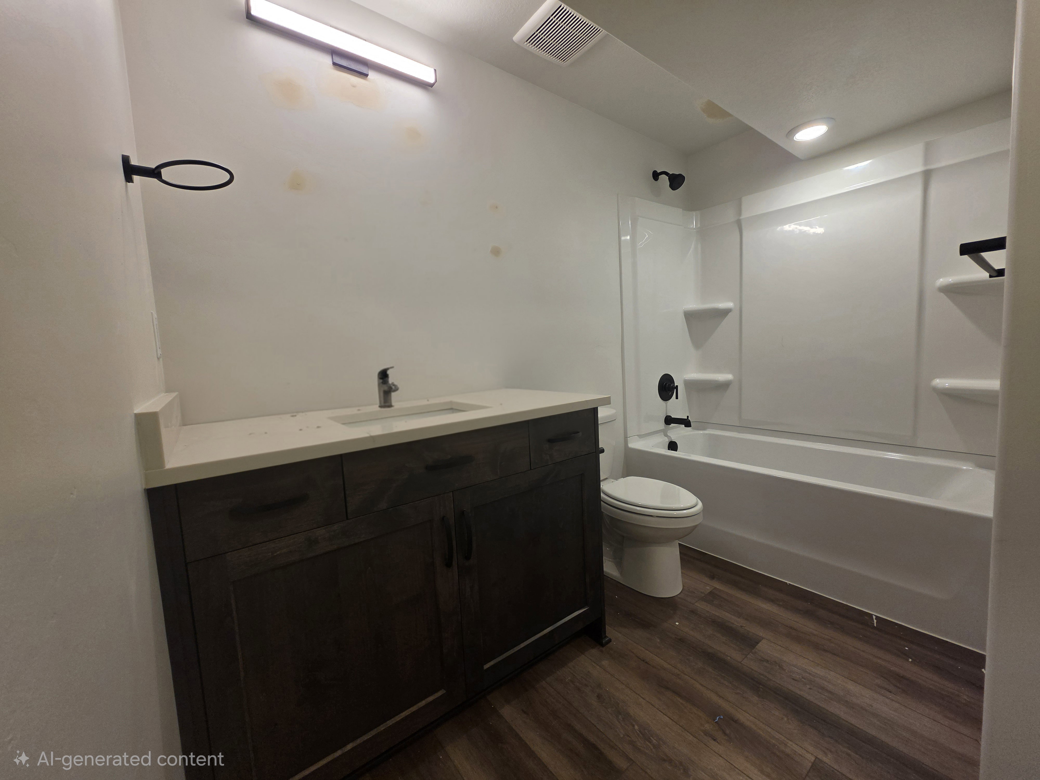 Modern bathroom featuring a wood-finish vanity with a light-colored countertop, an integrated sink, and a chrome faucet
