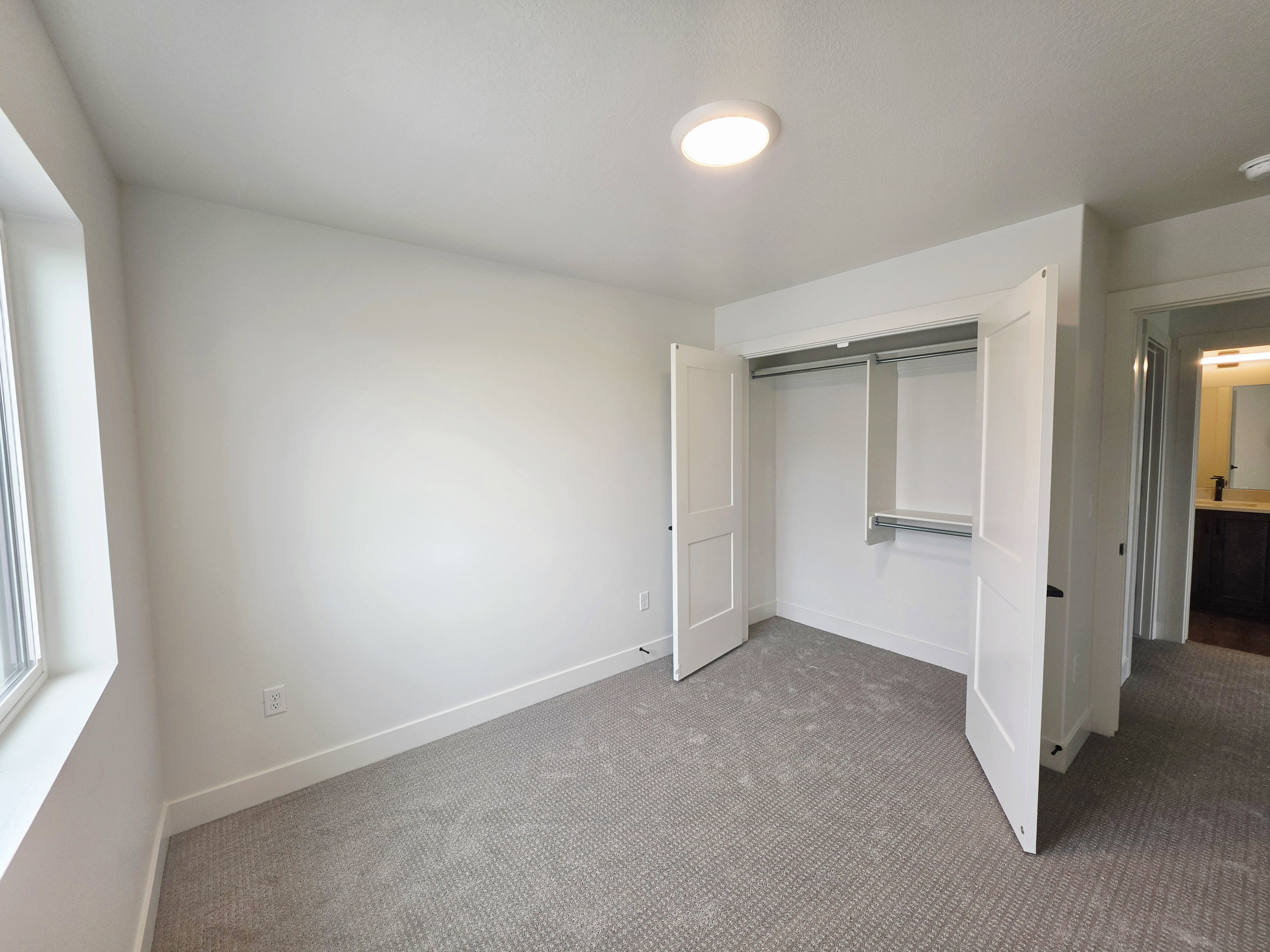 Room featuring light-colored walls and grey patterned carpet