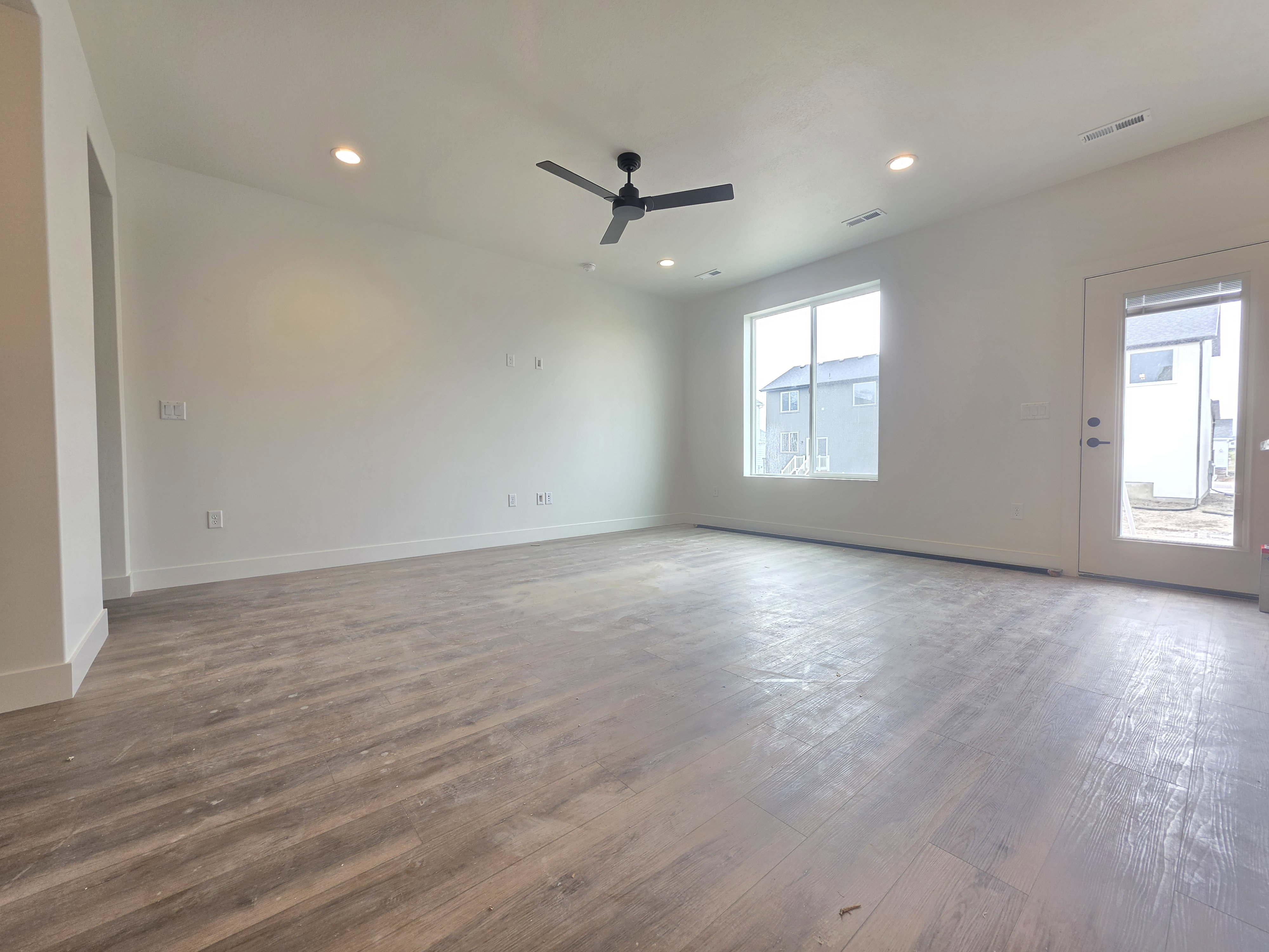 Spacious interior with wood-finish flooring, recessed lighting, and a modern ceiling fan