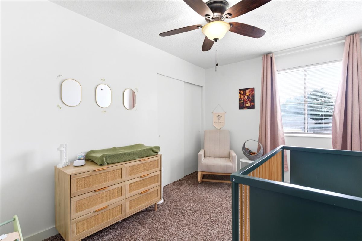 Room featuring neutral wall paint, a window with blinds, and a ceiling fan with integrated lighting