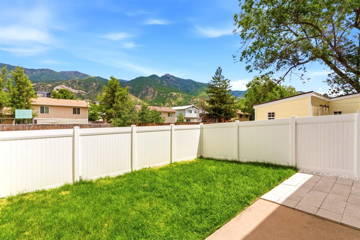Private backyard featuring a well-maintained lawn and a stone paver patio