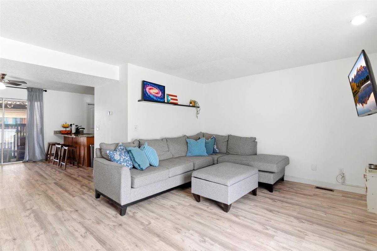 Bright living area featuring wood-finish flooring and white walls