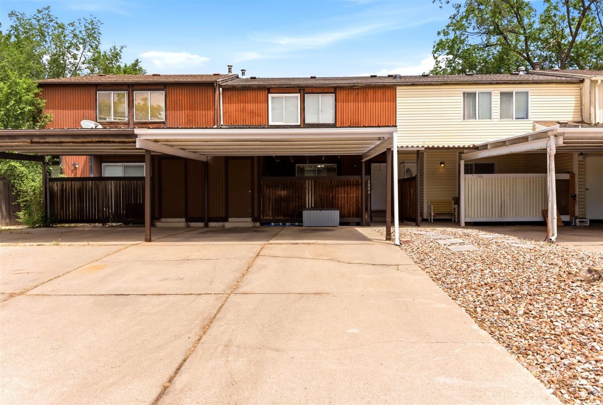 Front exterior showcasing a two-story building with covered carport parking