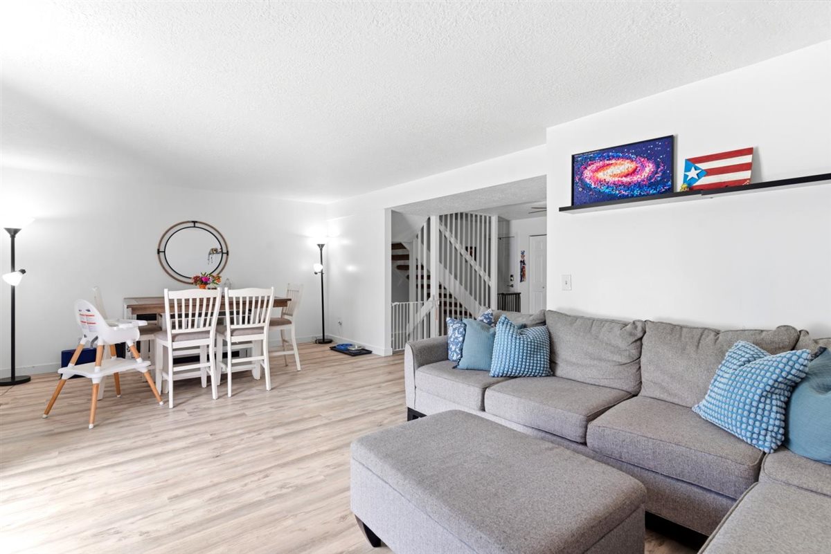 Bright open-concept living space with light-tone wood-finish flooring
