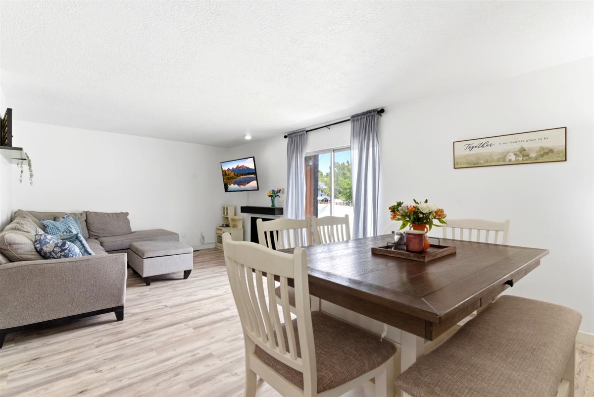 Open-concept living area with light wood-finish flooring, white walls, and recessed lighting