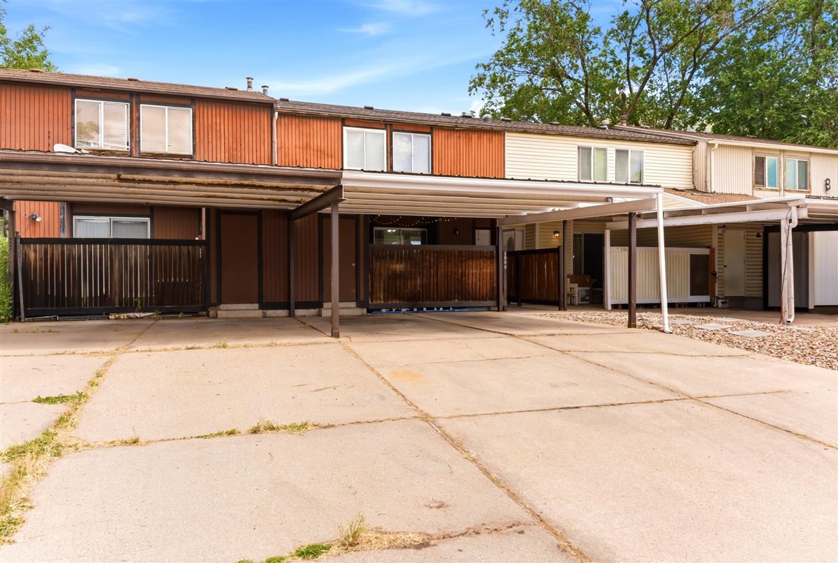 Multi-unit residential property featuring carports and concrete driveways