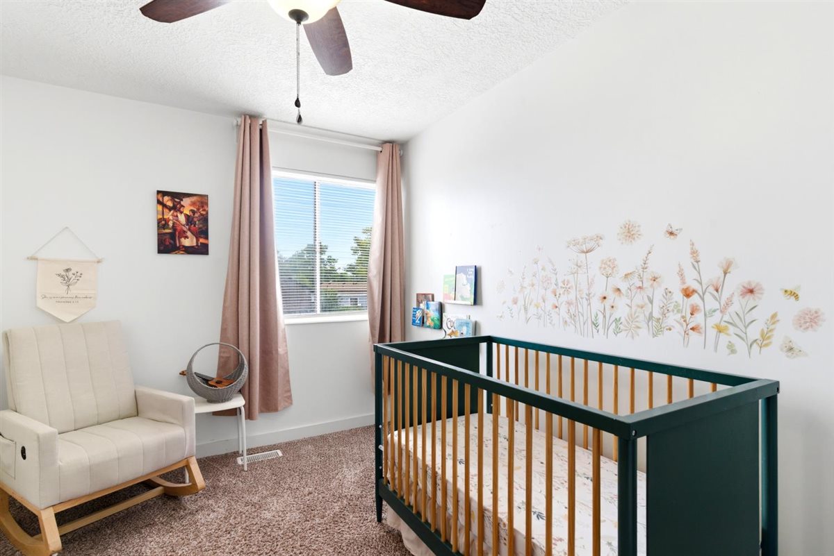 Room featuring a ceiling fan, window with blinds, and neutral carpet flooring