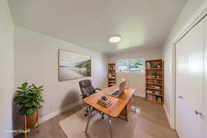Bright room featuring wood-finish flooring, a window offering natural light, and a ceiling-mounted light fixture