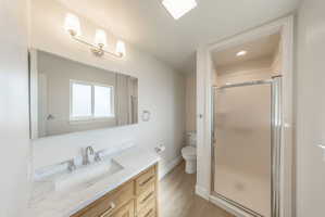 Bathroom featuring a light wood-finish vanity with a white countertop and undermount sink, brushed nickel faucet, and a large wall-mounted mirror